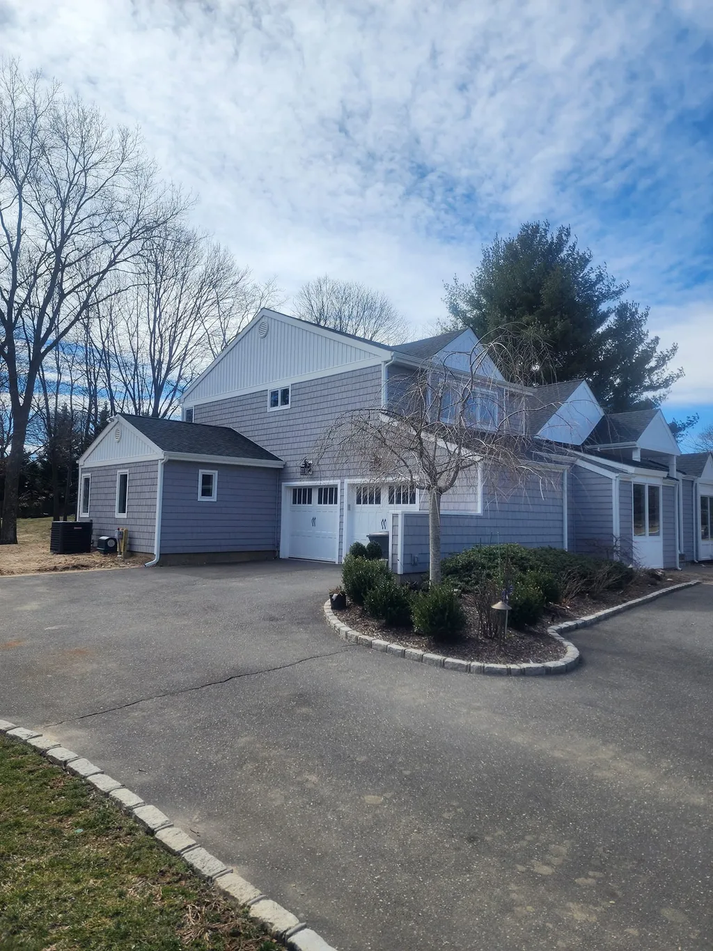Gray-sided Long Island home with a two-car garage after exterior work by Parisi Home Improvement